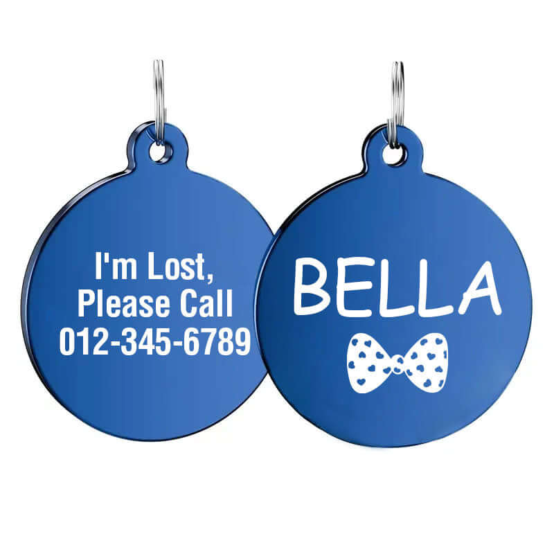 Custom blue round stainless steel dog tag engraved with the name 'Bella', a white bow design, and "I'm Lost, Please Call" message with phone number.
