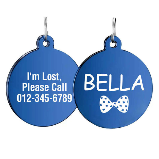 Custom blue round stainless steel dog tag engraved with the name 'Bella', a white bow design, and "I'm Lost, Please Call" message with phone number.