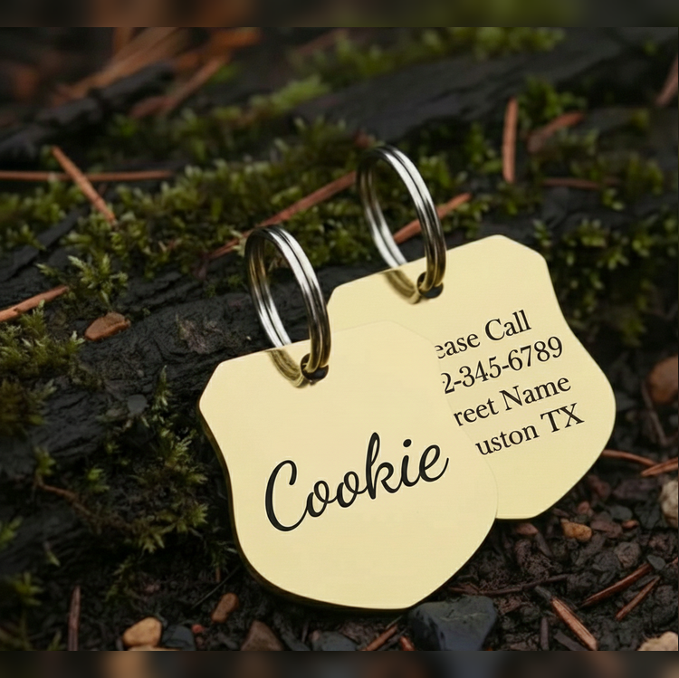 Gold pet tag with 'Cookie' engraved, on a natural background