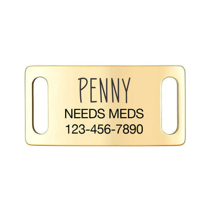 Gold slide-on dog ID tag labeled 'Penny Needs Meds' with contact number, essential for pet safety.