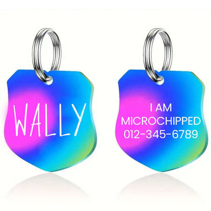 Colorful rainbow stainless steel shield-shaped pet ID tag engraved with the name 'Wally' on one side and 'I am microchipped' with contact number on the other; perfect for pet safety and stylish identification.